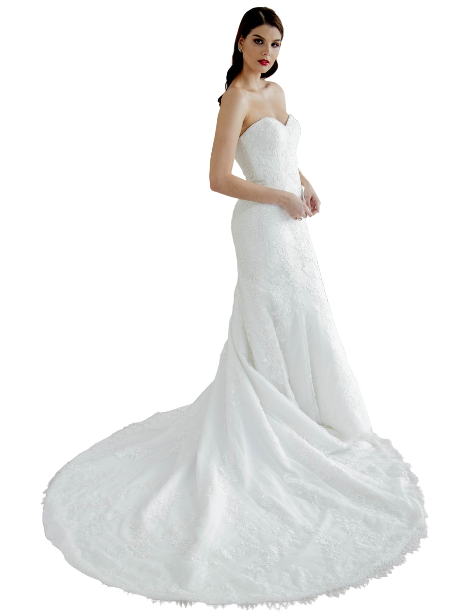 Anya vestido strapless falda sirena elaborado con delicado encaje. El escote corazón romántico y su diseño enmarca la silueta.