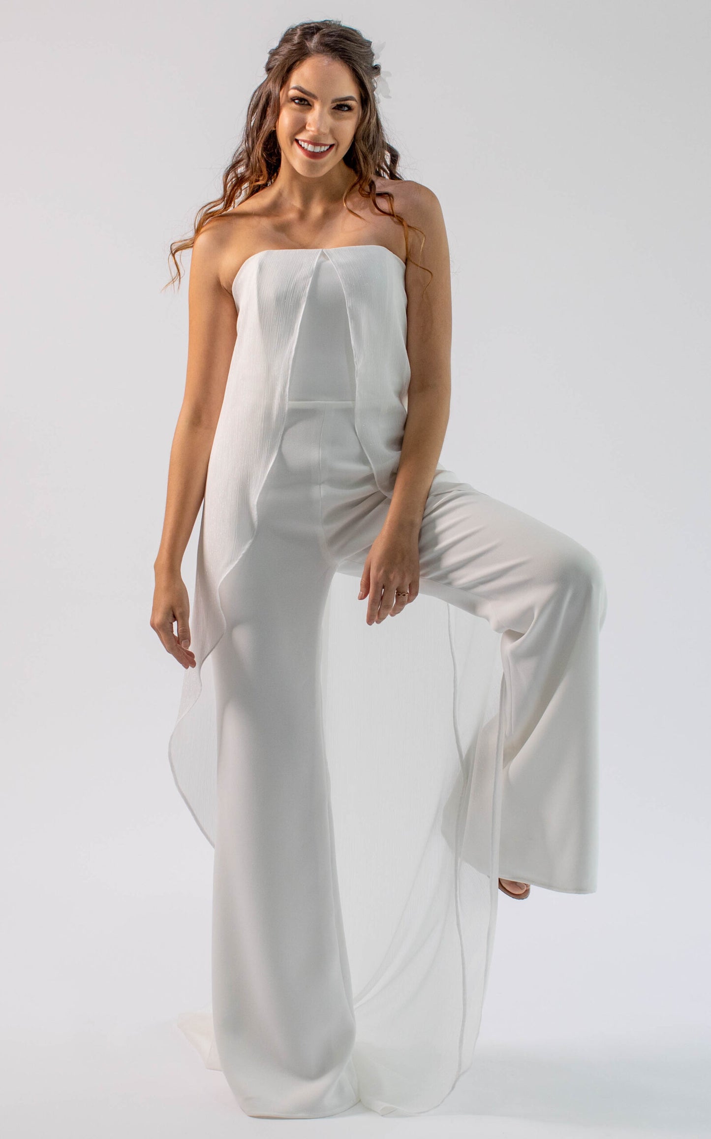 Jumpsuit Dalia con capa con top strapless y pantalón campana. Capa de tul sedoso que te dará un look femenino y especial en tu boda.